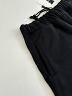 Black shorts with stitched front pocket seams and drawstring waist