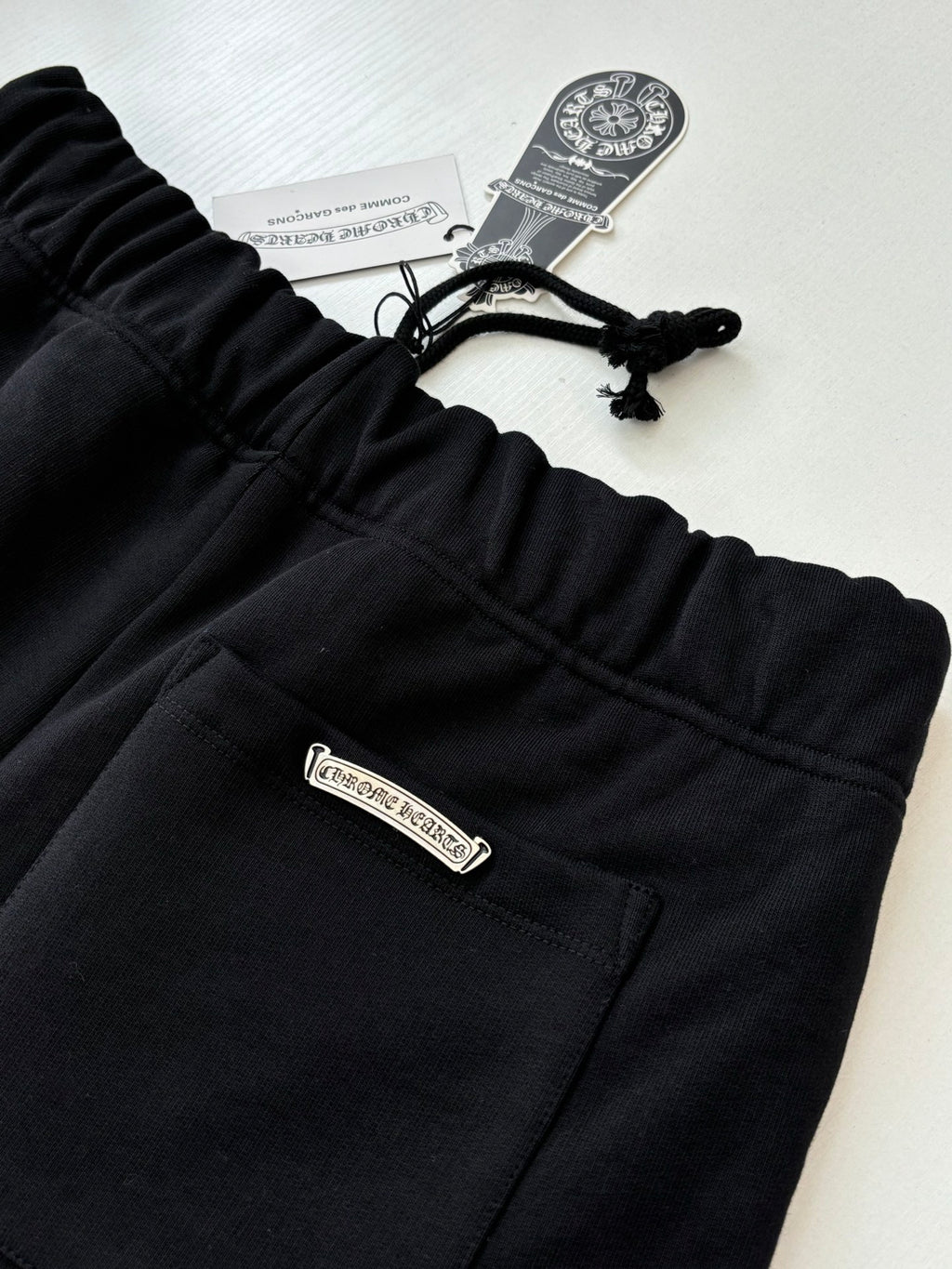Black elastic-waist shorts with small front logo patch