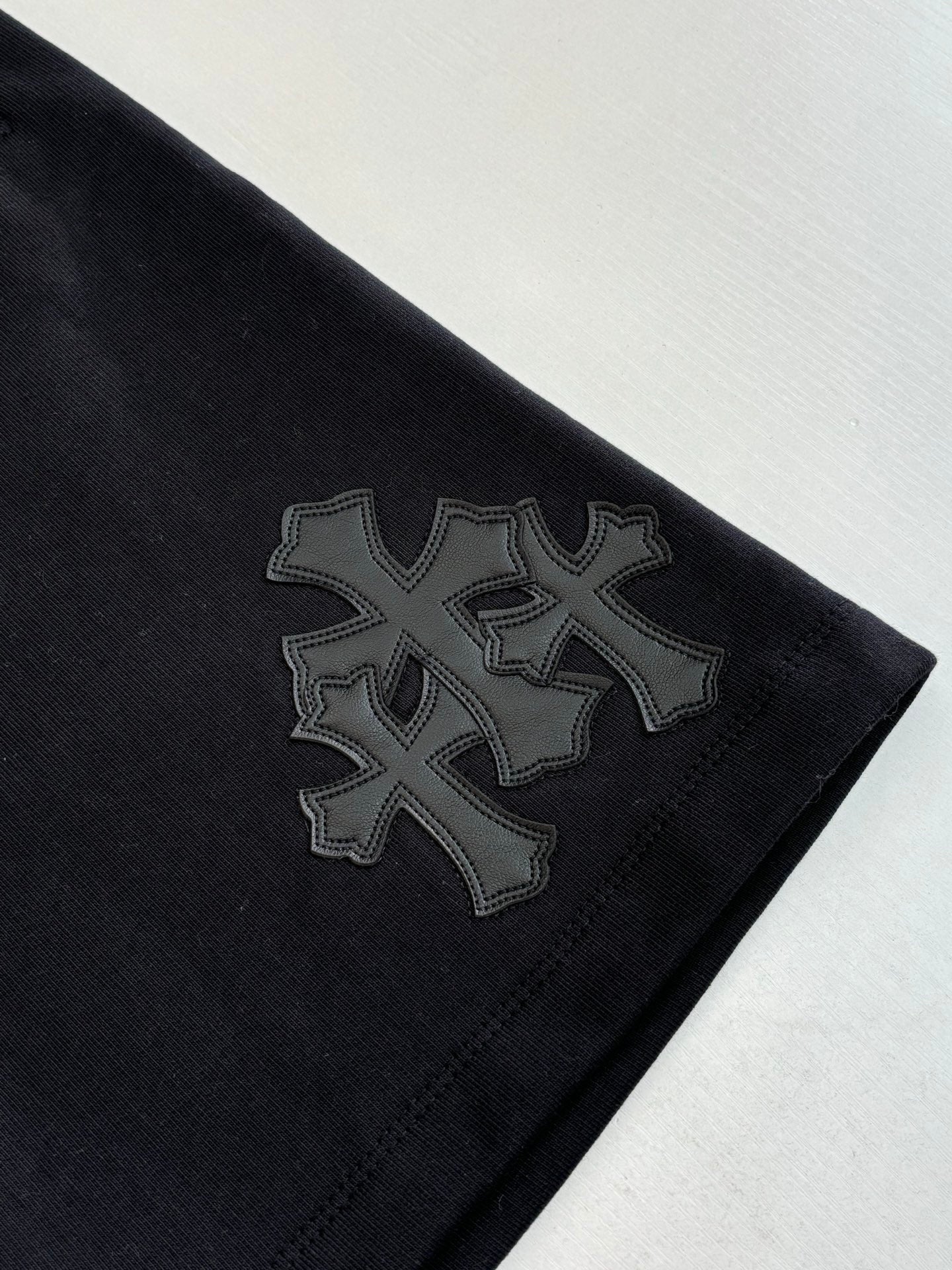 Black shorts with large embroidered cross-style side patch