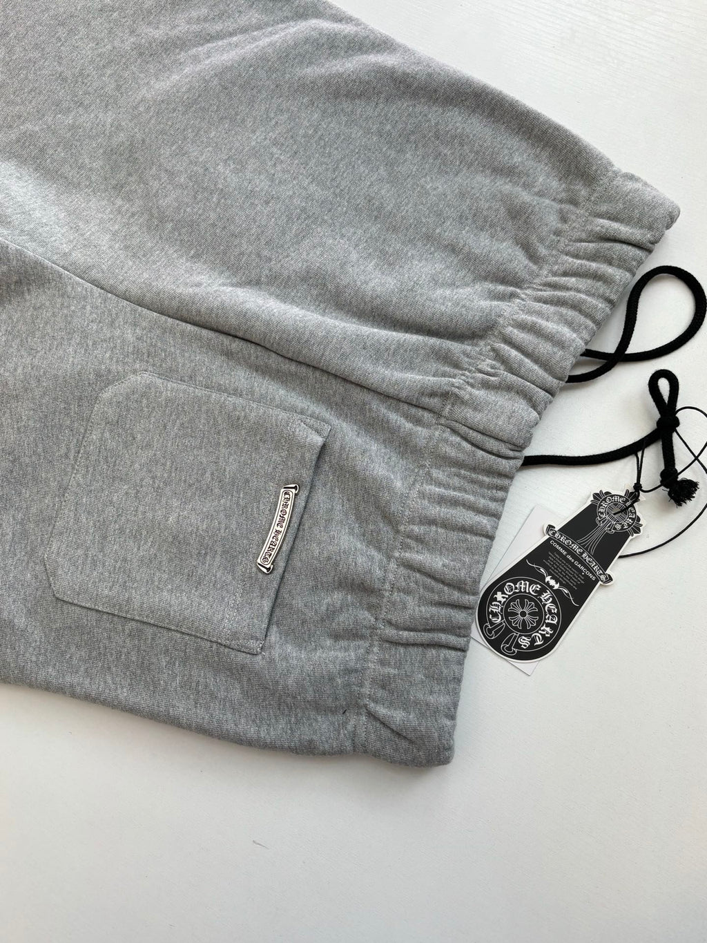 Heather gray shorts with drawstring, side pocket, and woven label at hem