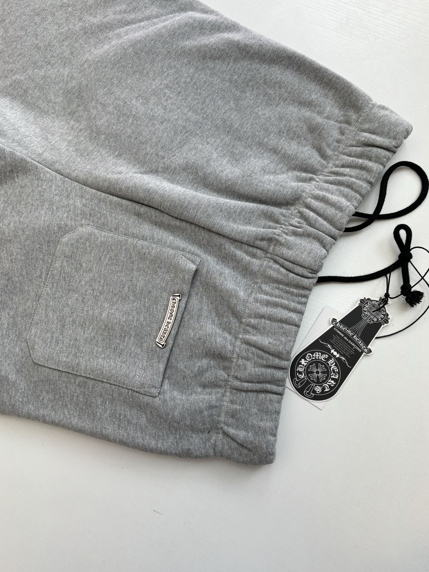 Heather gray shorts with drawstring, side pocket, and woven label at hem