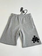 Heather gray shorts with drawstring waistband and black cross-style logo appliqué