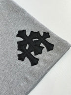 Black cross-style logo appliqué on heather gray shorts