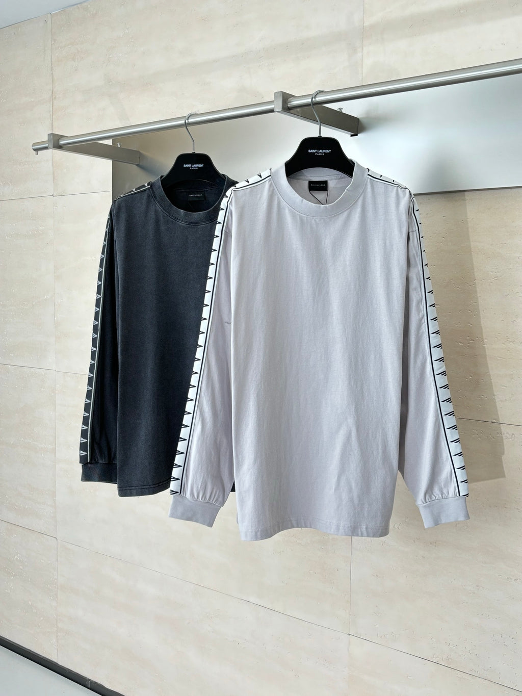 Pair of long-sleeve crewneck tops, light and dark gray, with graphic sleeve stripe