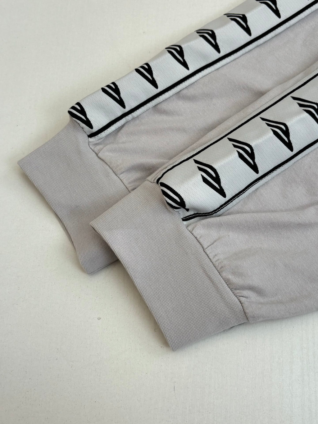 Light gray sleeve cuff with black logo stripe graphic trim