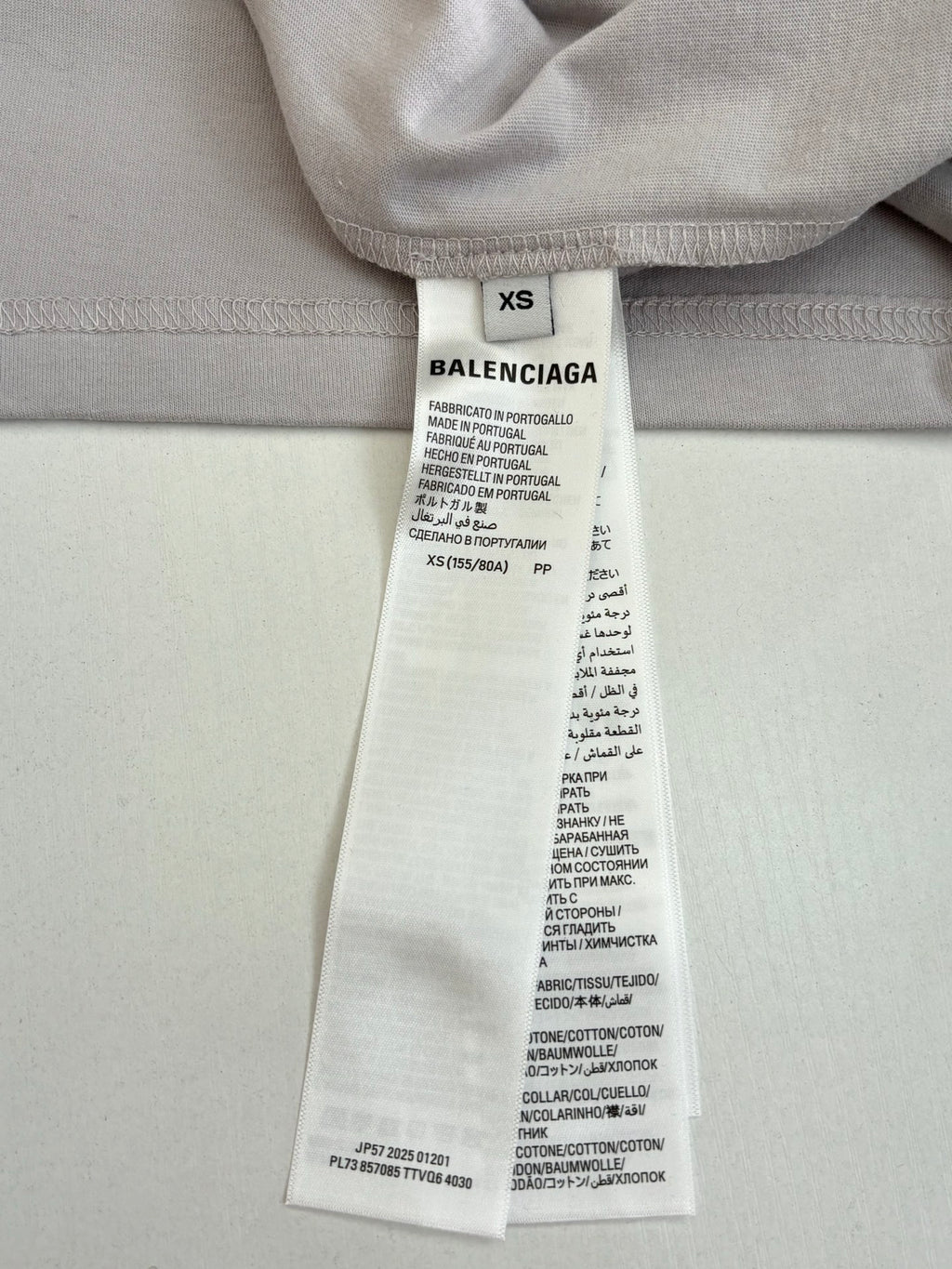 Light gray top size and care label with BALENCIAGA branding, XS marked