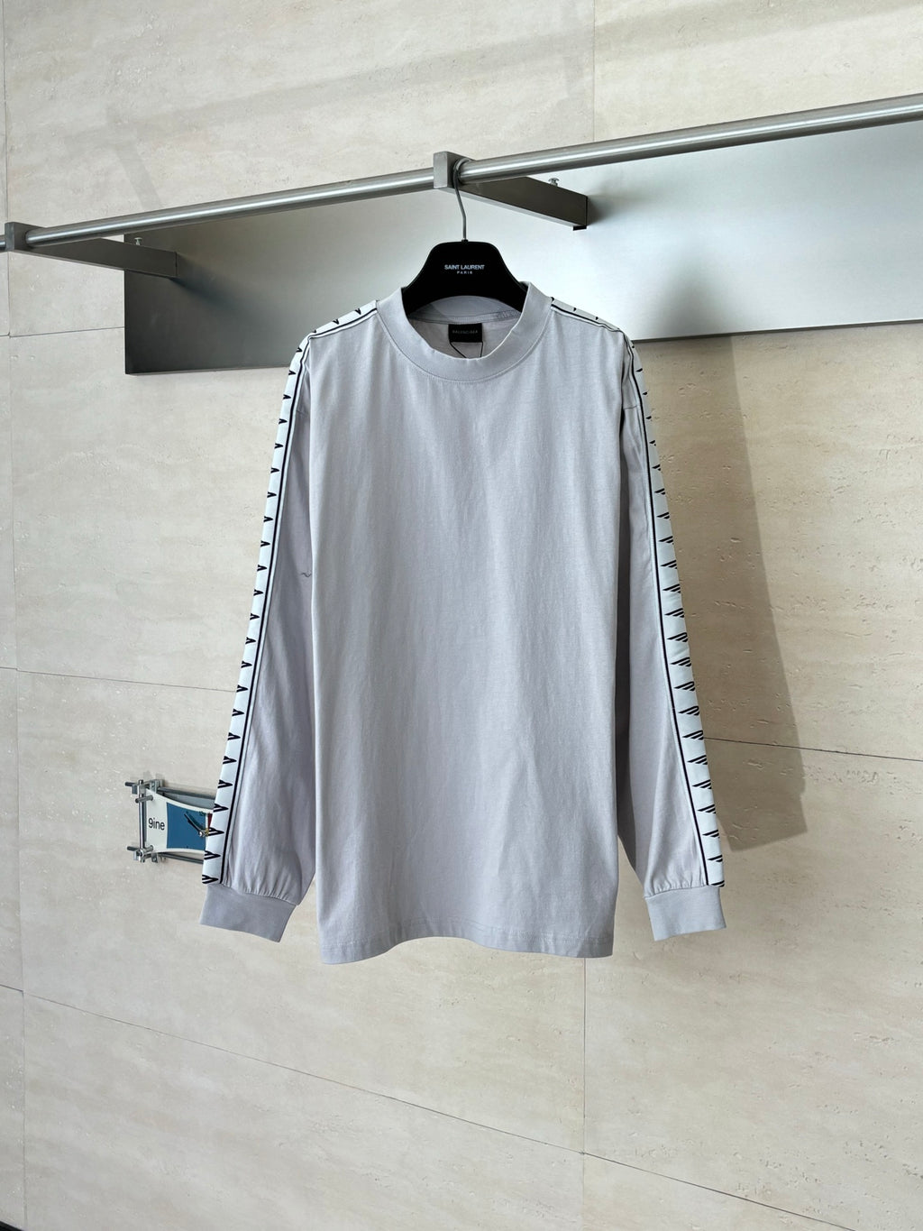 Light gray long-sleeve crewneck top with black logo trim on sleeves