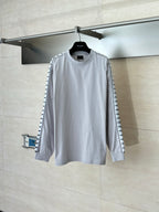 Light gray long-sleeve crewneck top with black logo trim on sleeves