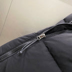 Dark puffer jacket zipper with metal pull and seam paneling