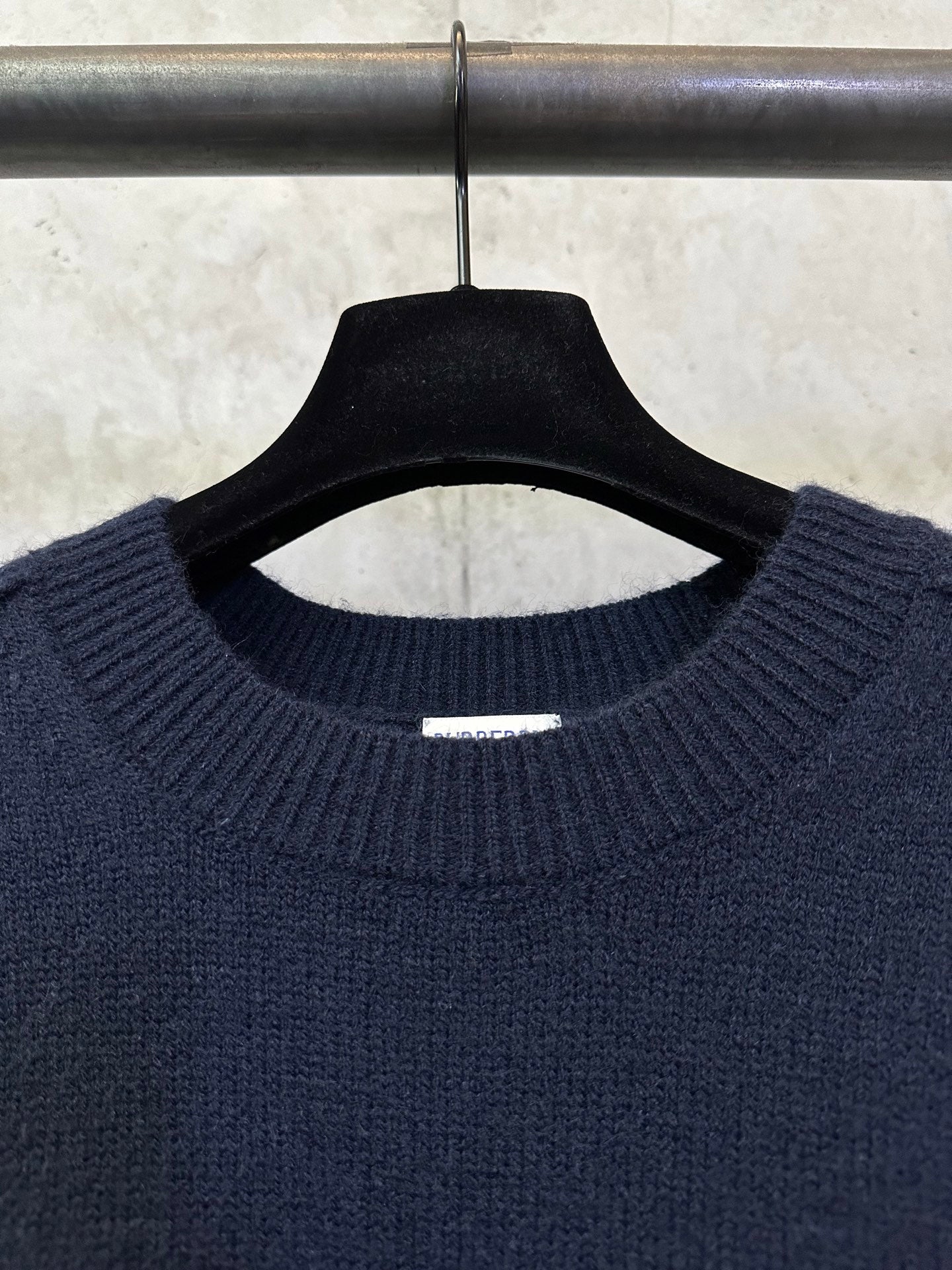 Navy crewneck sweater close-up of ribbed collar and neckline label