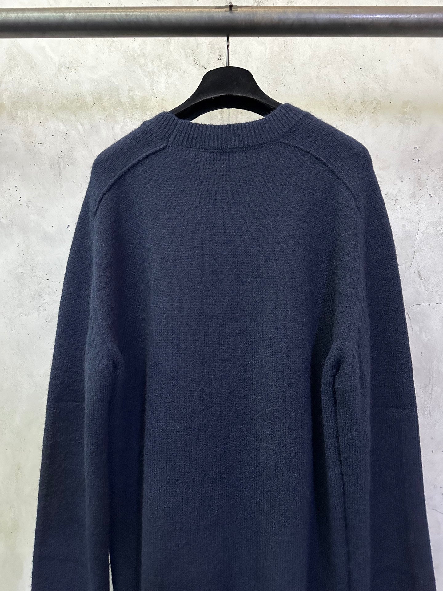 Navy crewneck sweater back view with ribbed cuffs and hem