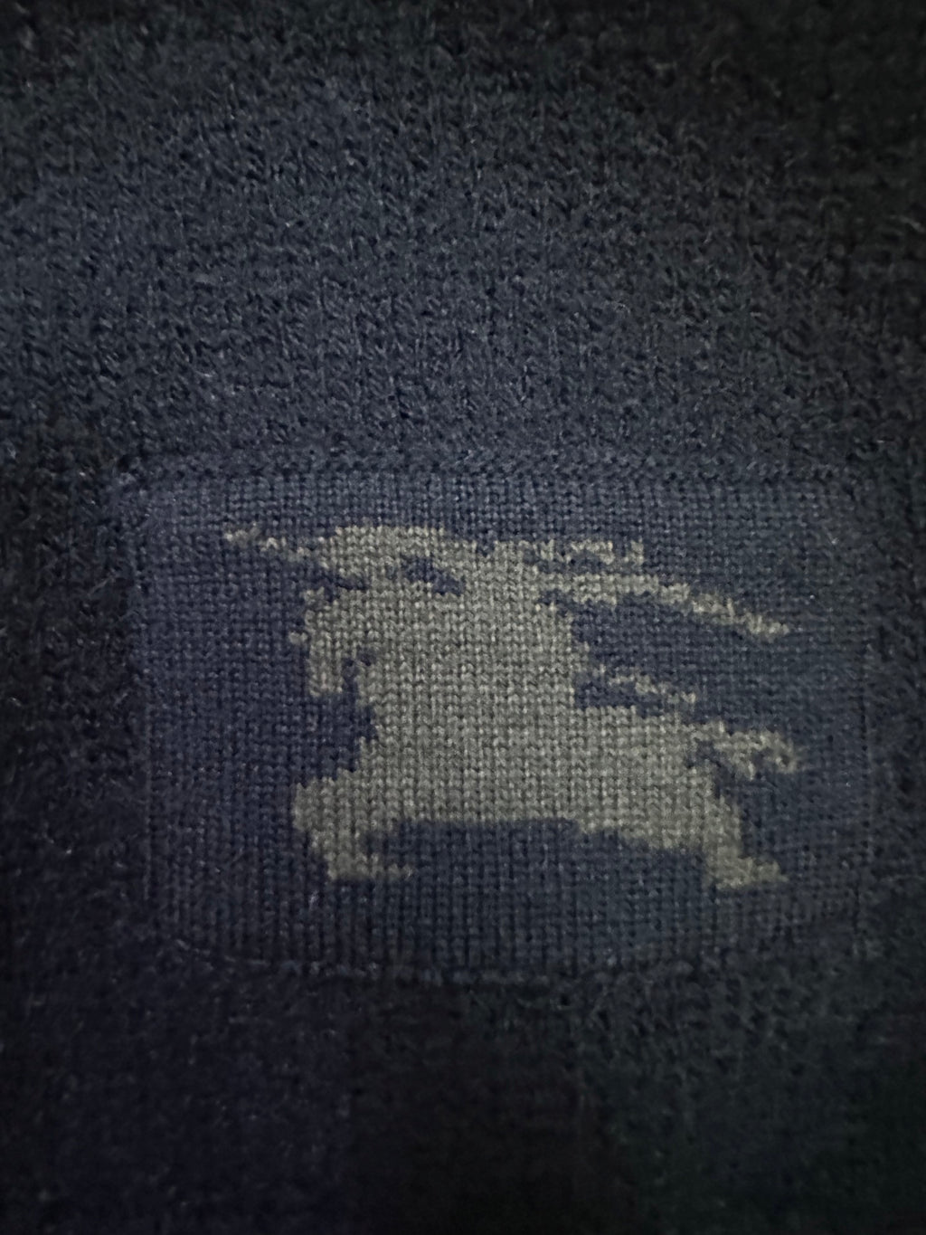 Navy knit sweater with visible Burberry horse logo patch