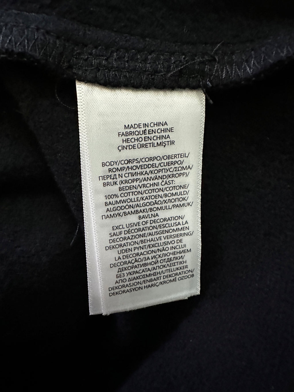 Black sweatshirt care label sewn at inside neckline