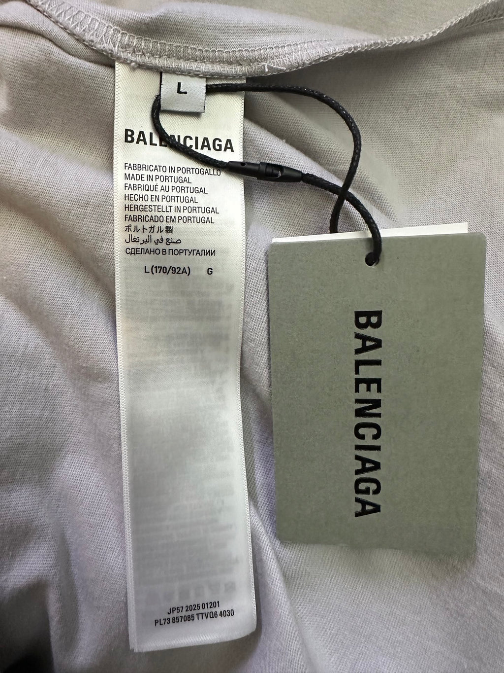 Balenciaga garment tags and size label on light off-white long-sleeve shirt