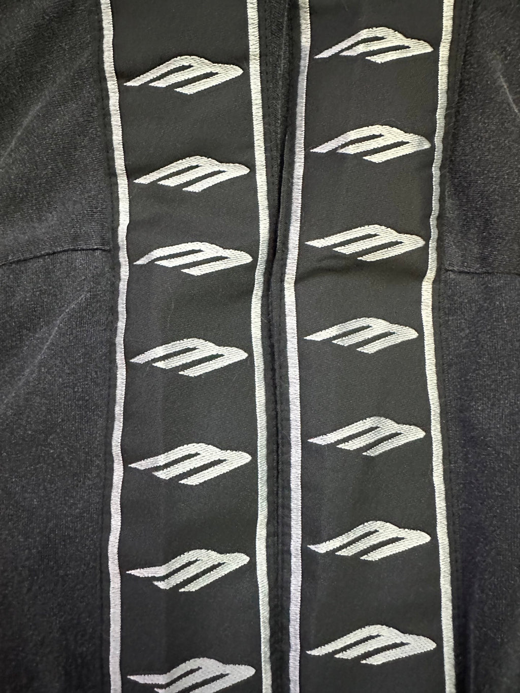 Black T-shirt sleeve with repeating white logo graphics and white trim