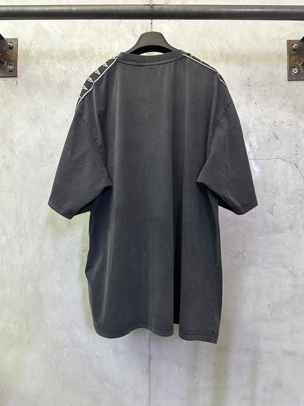 Men's black crew-neck T-shirt, back view with white logo tape along sleeves