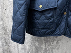 Ralph Lauren quilted jacket close-up, navy blue, front flap pocket with gold button