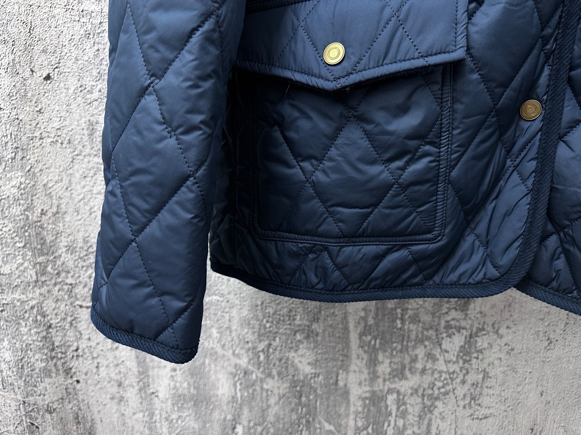 Ralph Lauren quilted jacket close-up, navy blue, front flap pocket with gold button