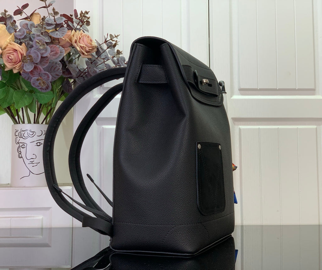 Louis Vuitton backpack angled view with front flap, side pocket, and adjustable shoulder straps