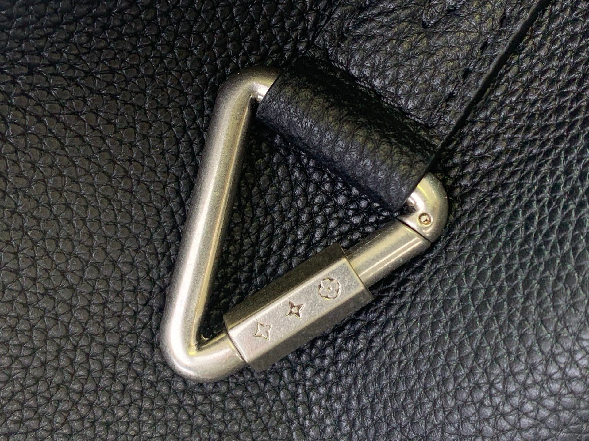 Louis Vuitton backpack close-up of gold-toned metal corner hardware on textured leather