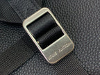 Louis Vuitton backpack close-up of gold-toned buckle on textured leather strap