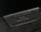 Louis Vuitton leather backpack close-up of embossed brand logo on flap