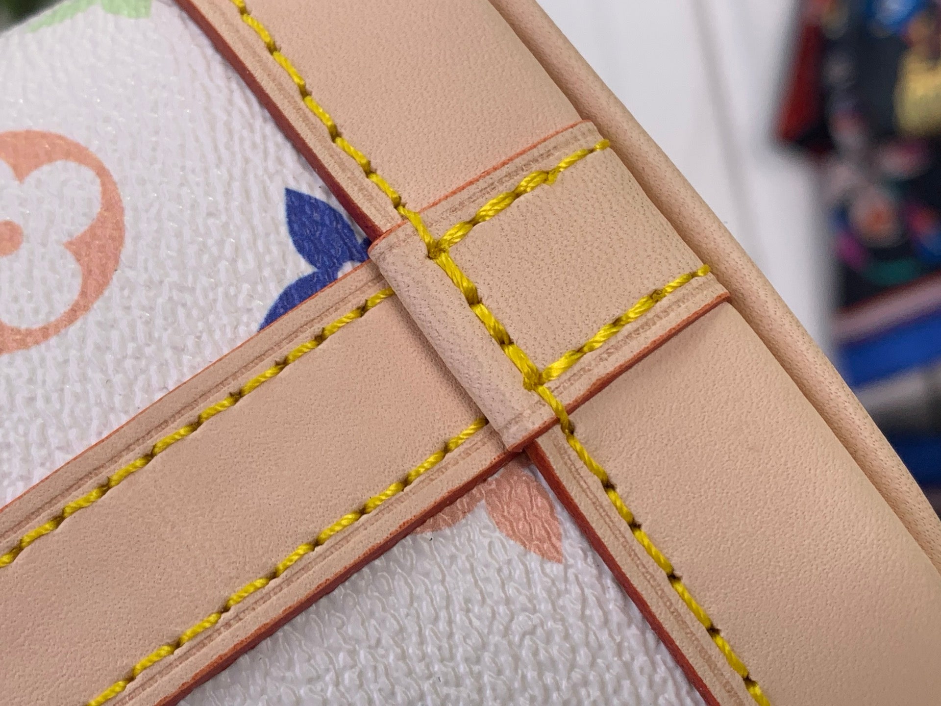 Leather cross-stitch detail with multicolor edging on monogram bucket bag