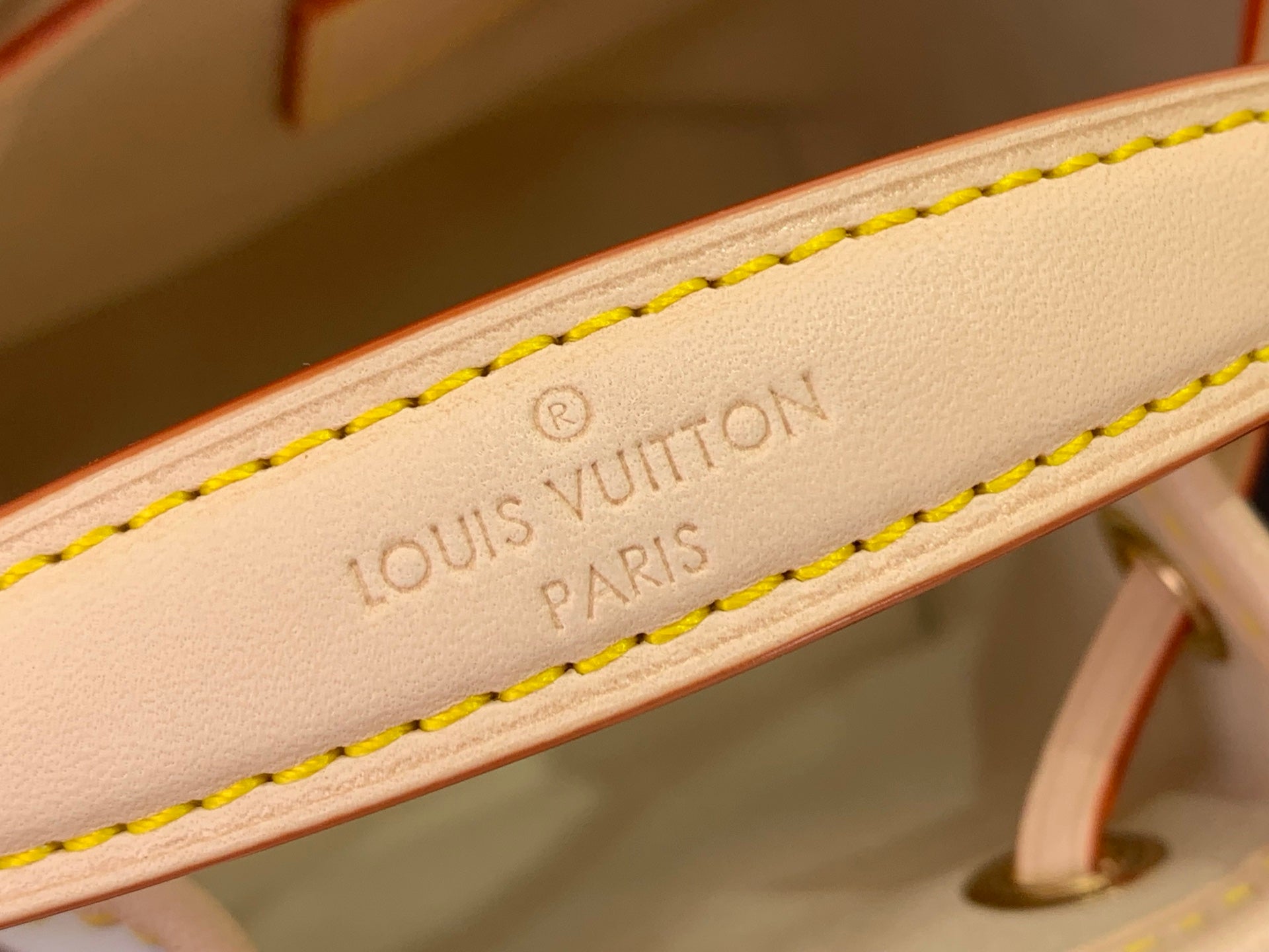 Louis Vuitton Paris embossed on light leather strap with yellow edge stitching