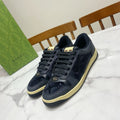 Gucci unisex sneakers in dark navy suede with lace-up and cream sole trim.