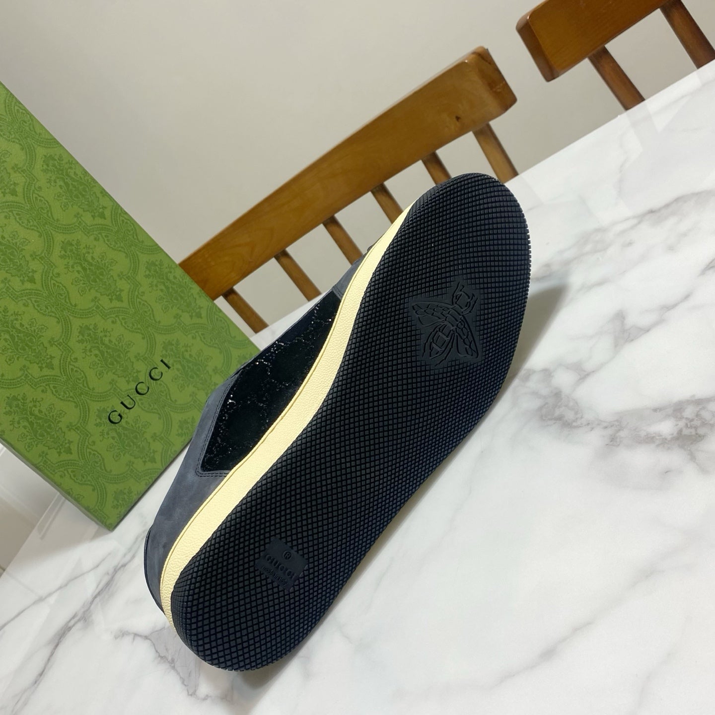 Gucci unisex sneaker outsole in dark navy with tread and cream sidewall logo detail.