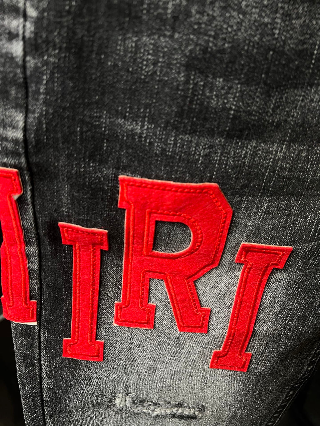 Gray denim fabric close-up with large red 'TR1' lettering