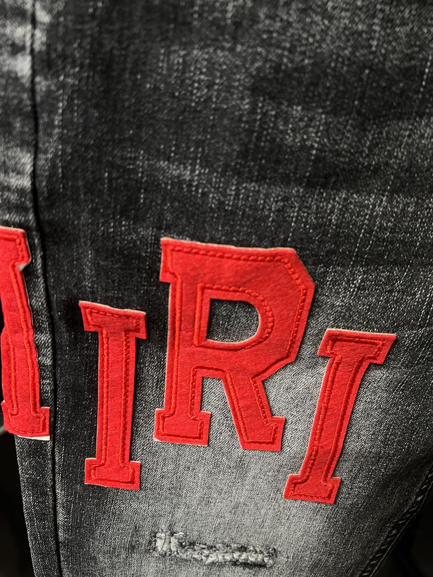 Gray denim fabric close-up with large red 'TR1' lettering