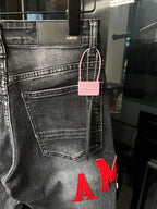 Gray denim jeans with front pocket, pink hang tag, and red 'AM' lettering