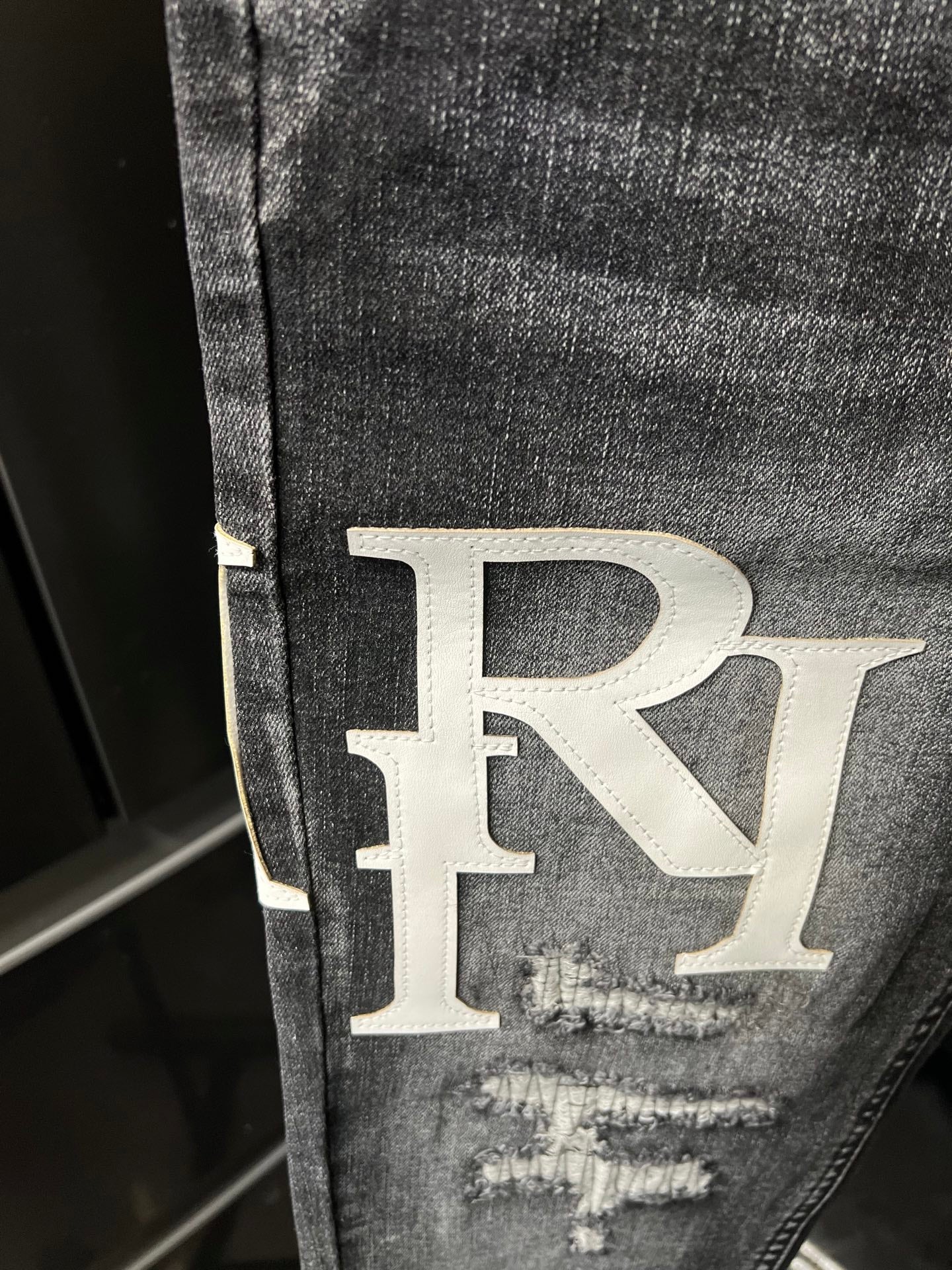 Light-wash denim jeans with large RL logo patch and distressed knee rip