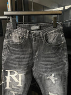 Light-wash denim jeans with AMIRI waistband label and RI patch at left leg