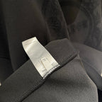Black hoodie care label on sleeve cuff with embroidered logo detail