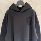 Black pullover hoodie with hood, face patch on chest, and kangaroo front pocket