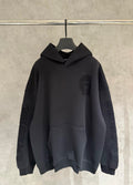 Black long-sleeve pullover hoodie with hood and front pocket, subtle logo patch