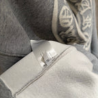 Gray hoodie fabric close-up with inner label near the sleeve cuff.