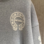 Gray hoodie sleeve with large circular emblem print.