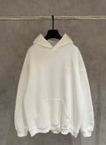 Off-white long-sleeve hoodie with hood and kangaroo pocket, embossed face chest logo
