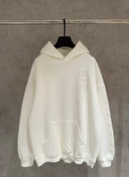 Off-white long-sleeve hoodie with hood and kangaroo pocket, embossed face chest logo