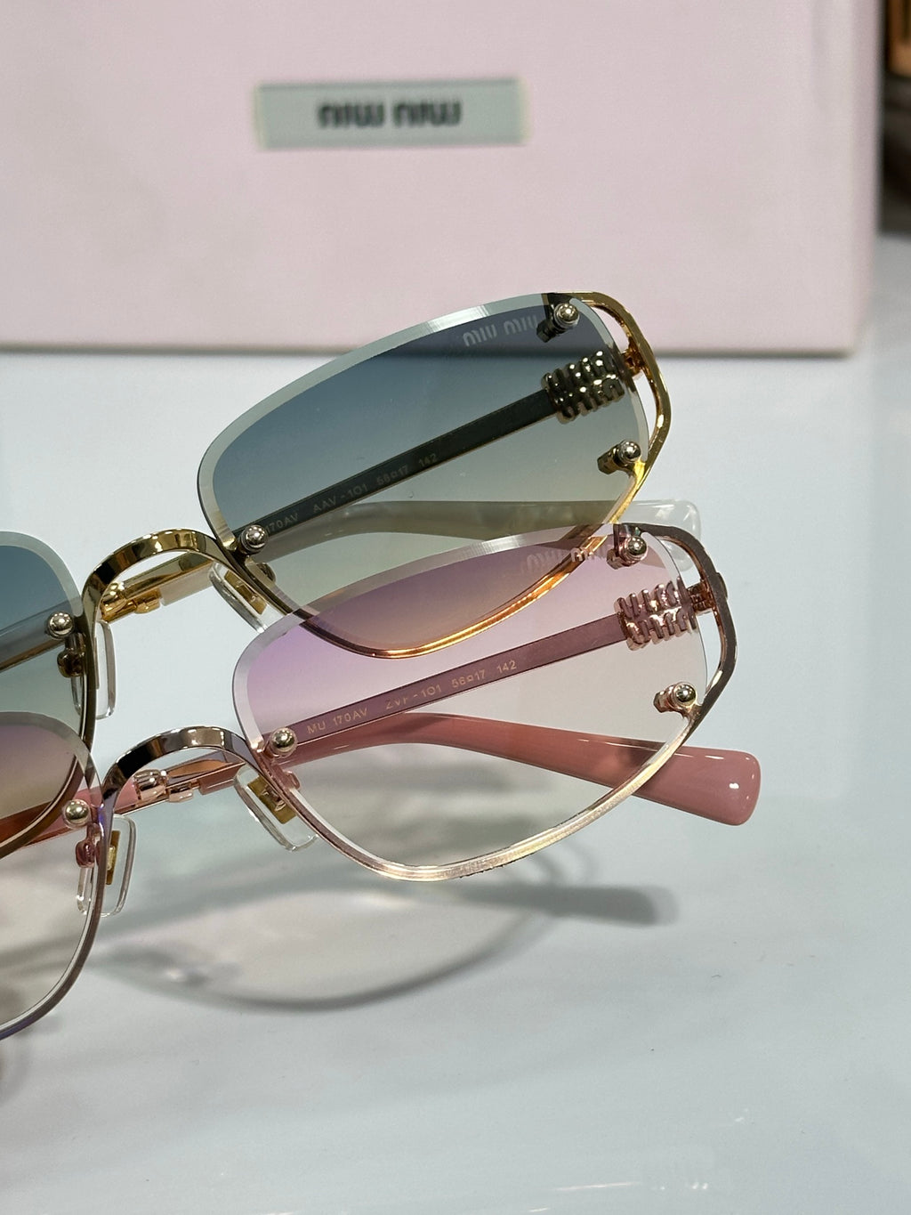 MiuMiu sunglasses set: gold blue-lens and rose-pink lens frames, side view
