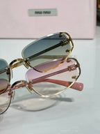 MiuMiu sunglasses set: gold blue-lens and rose-pink lens frames, side view