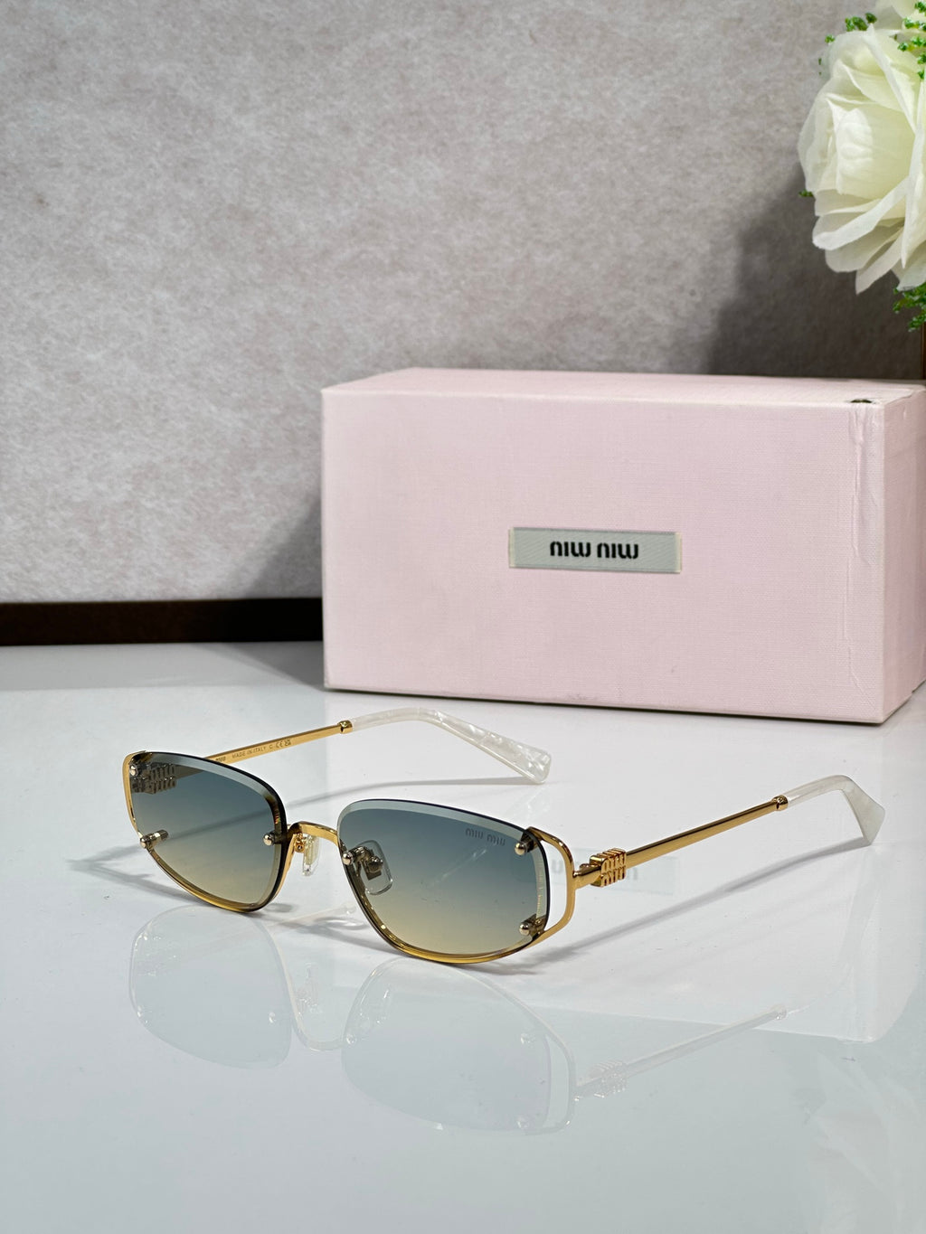 MiuMiu sunglasses with blue-tinted lenses and gold round frames