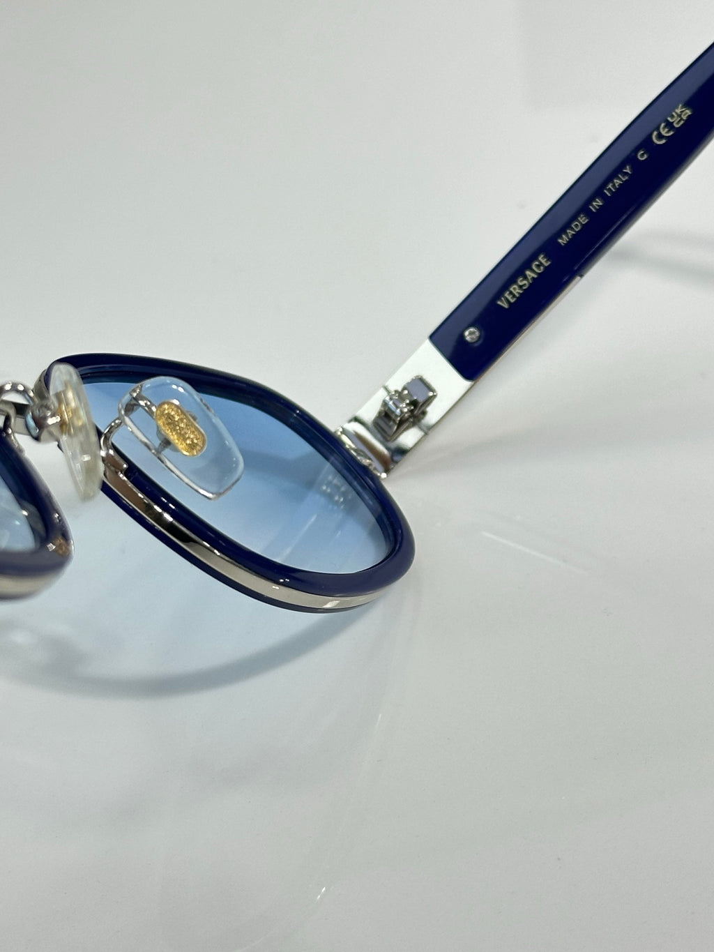 Versace sunglasses close-up with blue frame and metal hinge details