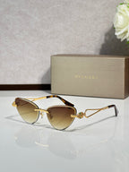 Gold-frame cat-eye sunglasses with amber lenses and jeweled bridge