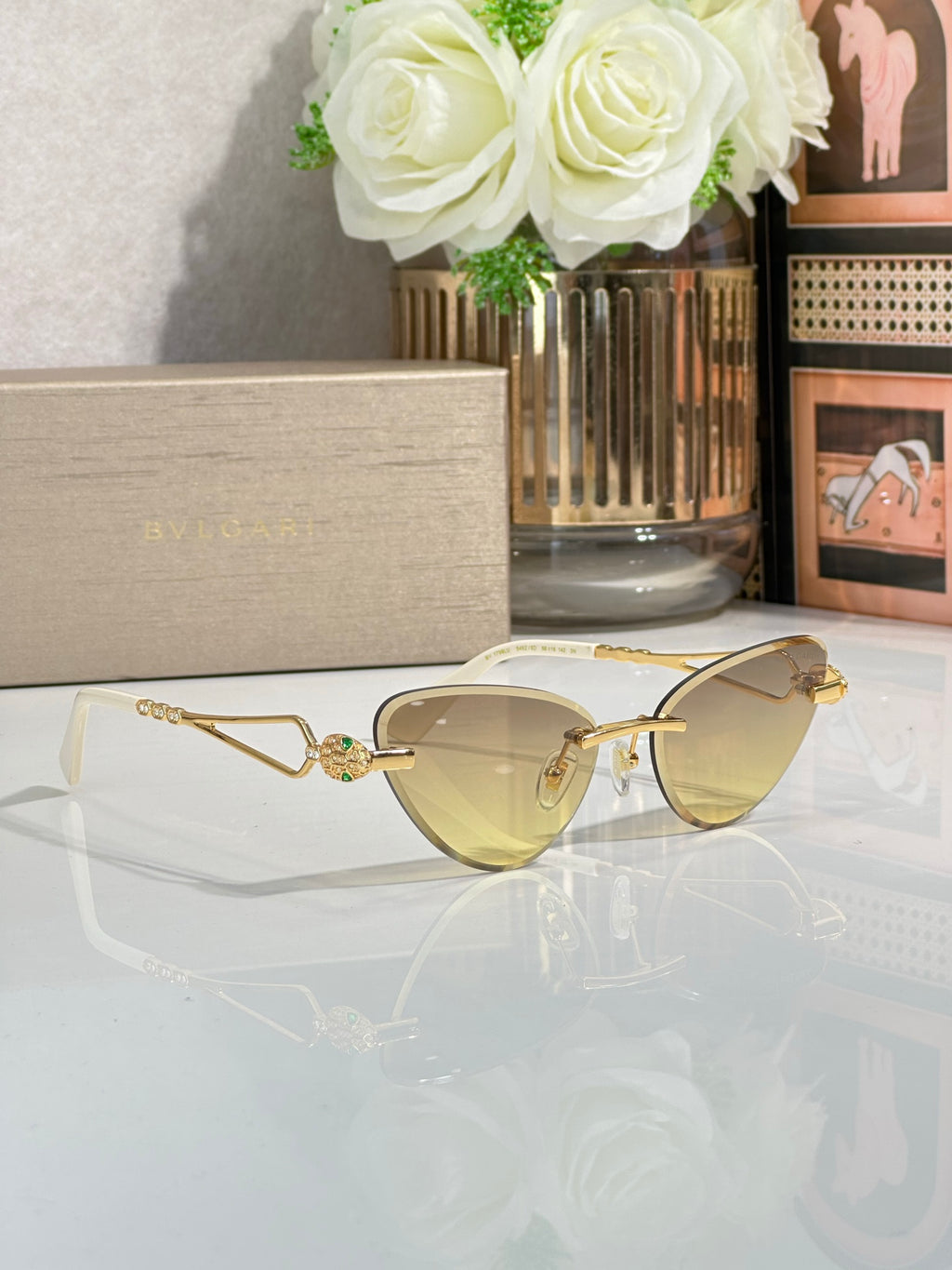 Gold-frame cat-eye sunglasses with pale yellow lenses, side angle