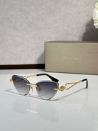 Gold-frame cat-eye sunglasses with dark blue lenses and jeweled bridge