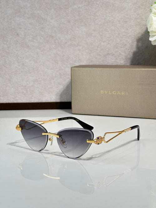 Gold-frame cat-eye sunglasses with dark blue lenses and jeweled bridge